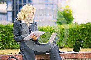 Office worker secretary woman writing on a piece of paper in a notebook. Businesswoman working outside on the street