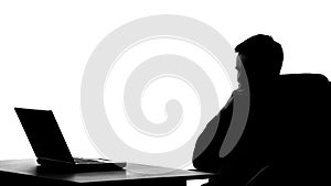 Office worker silhouette thinking about business project in front of laptop pc