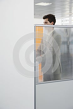 Office Worker Standing Behind Cubicle Wall