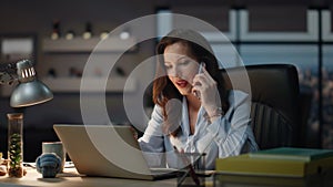 Office worker staying late discussing at night cabinet. Business woman calling