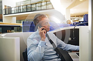 Office worker talking phone and browsing laptop