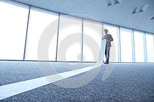 Office worker unrolling long sheet