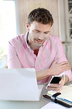 Office worker using laptop and phone