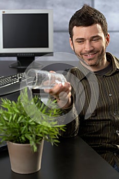 Office worker watering plant