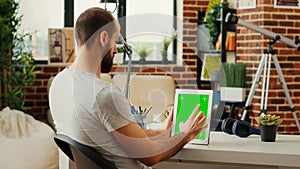 Office worker working with isolated greenscreen display on wireless device