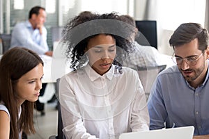 Office workers with African American female leader using laptop