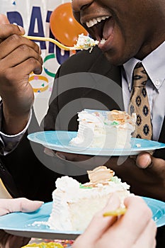 Office workers eating party cake