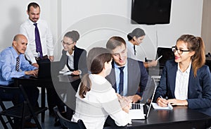 Office workers with laptops having a productive day at work