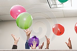 Office workers playing with balloons