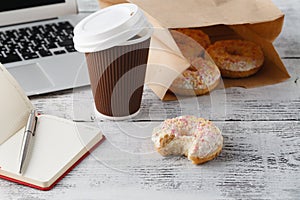 Office workplace with breakfast. Donuts and coffee