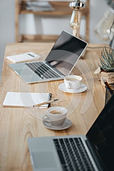 Office workplace with coffee and laptop computers