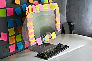 Office workplace with desktop pc full of blank colorful sticky notes