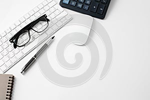 Office workplace with keyboard mouse glasses pen and calculator on white background