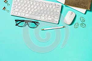 Office workplace with keyboard, notepad, glasses and pen