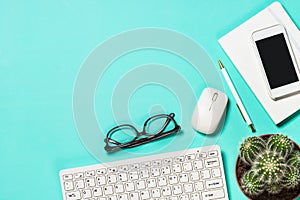 Office workplace with keyboard, notepad, succulent and pen