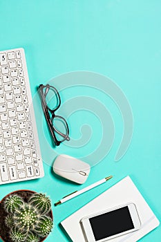 Office workplace with keyboard, notepad, succulent and pen