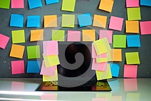 Office workplace with laptop and blank colorful sticky notes reminders