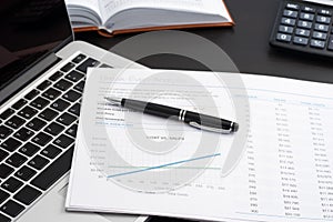 Office workplace, laptop and graphs