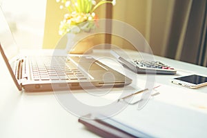 Office workplace with laptop and smart phone on white table