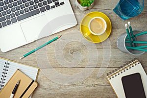 Office workplace table background with laptop computer, notebook and coffee cup