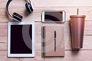 Office workplace. Wooden desk background with laptop, mobile phone, Headphone, Stainless and tumbler cup , tablet, book, pen