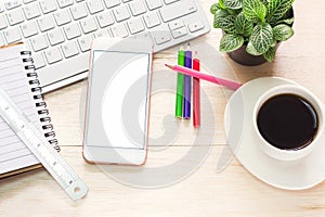 Office workspace with keyboard notepad coffee of cup and smartphone on wood table