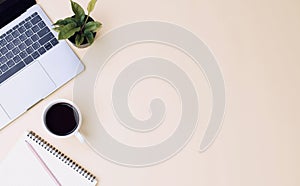 office workspace yellow desk table with laptop, coffee, mobile, notebook, plant