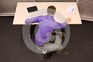 Office yoga - business man exercising at desk