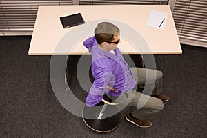 Office yoga - business man exercising at desk