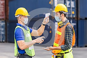 Officer checking fever team engineer and technician foreman with digital thermometer in cargo container shipping.