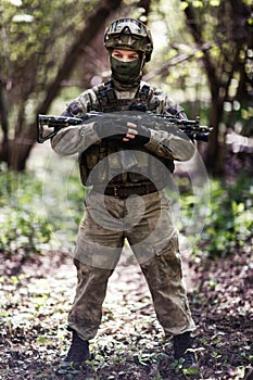 Officer with gun patrols forest photo