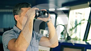 Officer during navigational watch looking through binoculars