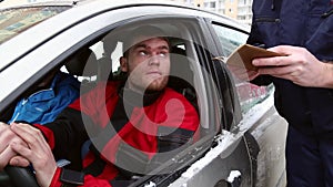 The officer of traffic police checks the documents of the driver