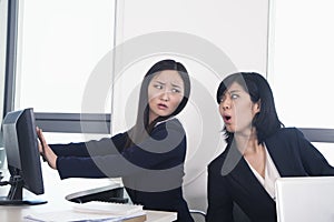 Officer worker hiding her computer from coworker photo