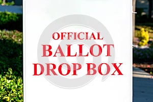 Official ballot drop box sign on white collection box set up outdoor during election