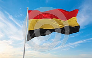 official flag of Belgium 1830 , Belgium at cloudy sky background on sunset, panoramic view. Belgian travel and patriot concept.