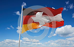 official flag of Bundesrepublik schweizreich Austria at cloudy sky background on sunset, panoramic view. Austrian travel and