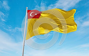 official flag of General Directorate of Health for Borders and Coasts of Turkey Turkey at cloudy sky background on sunset,