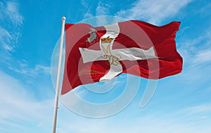 official flag of Jutland Dragoon Regiment, Denmark at cloudy sky background on sunset, panoramic view. Danish travel and patriot