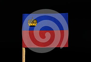 A official flag of Liechtenstein on toothpick on black background. Horizontal bicolour of blue and red; charged with a gold crown