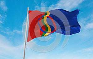 official flag of Sami, Norway at cloudy sky background on sunset, panoramic view. Norwegian travel and patriot concept. copy space