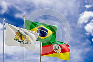 Official flags of the country Brazil, state of Rio Grande do Sul and city of Caixias do Sul. Swaying in the wind under the blue