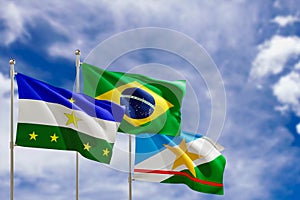 Official flags of the country Brazil, state of Roraima and city of Rorainopolis. Swaying in the wind under the blue sky. 3d