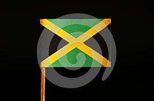 A official and original Flag of Jamaica on toothpick and on black background. Jamaica located in the central america.