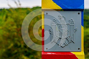 Official plate with the coat of arms of the state of the Republic of Moldova on a customs or border post. Background
