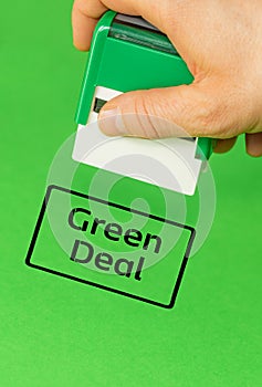 Official putting a stamp approving the Green Deal, Green background, vertical, copy space