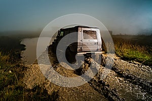 Offroad car on bad road. Water splash in off-road racing. Wheel close up in a countryside landscape with a muddy road.