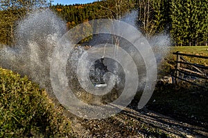 Offroad car crossing river with big water splash