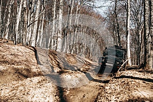 Offroad car driving through the forest road of mud