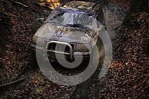 Offroad car going through deep mud holes